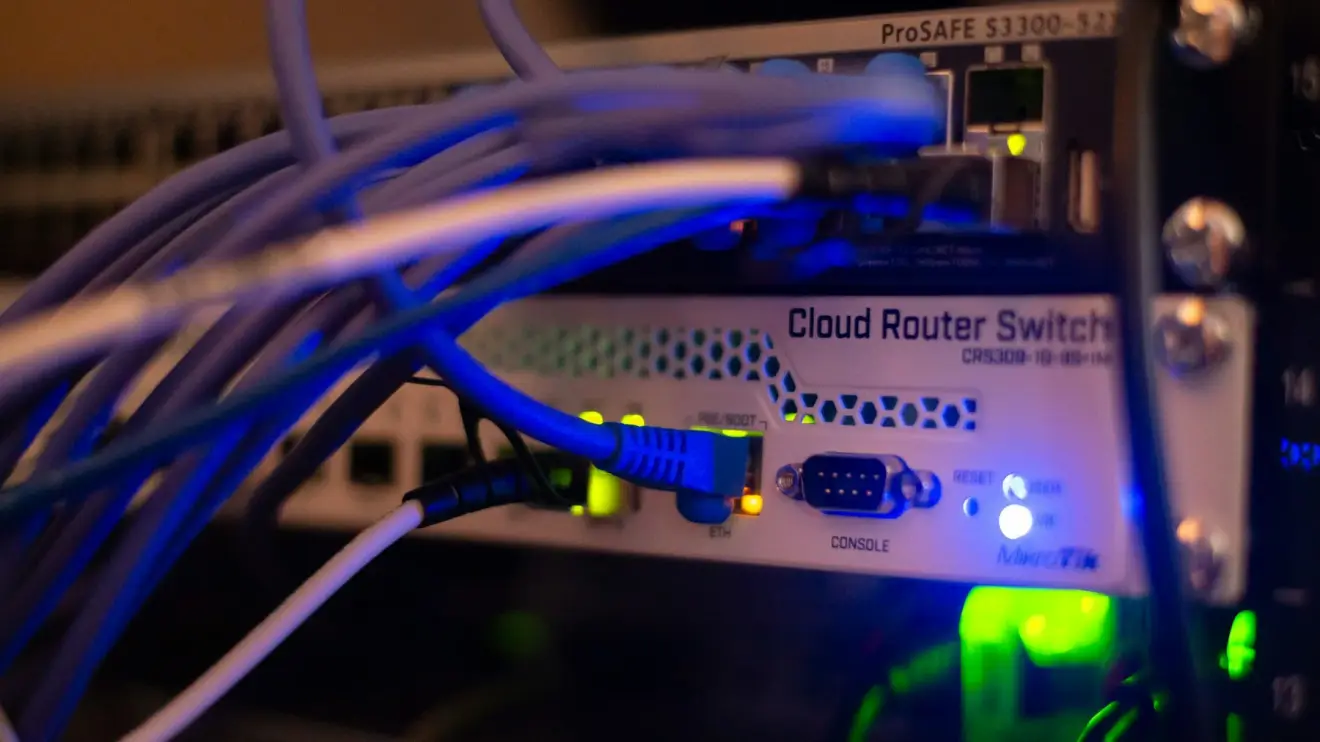 Ethernet cables connected to network switches with illuminated status indicators.