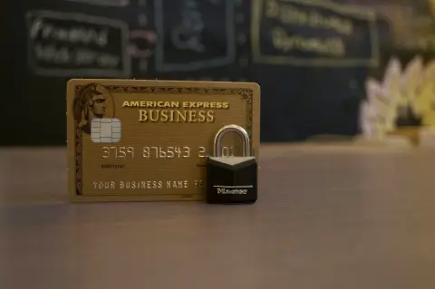An American Express sample business card beside a small padlock on a counter