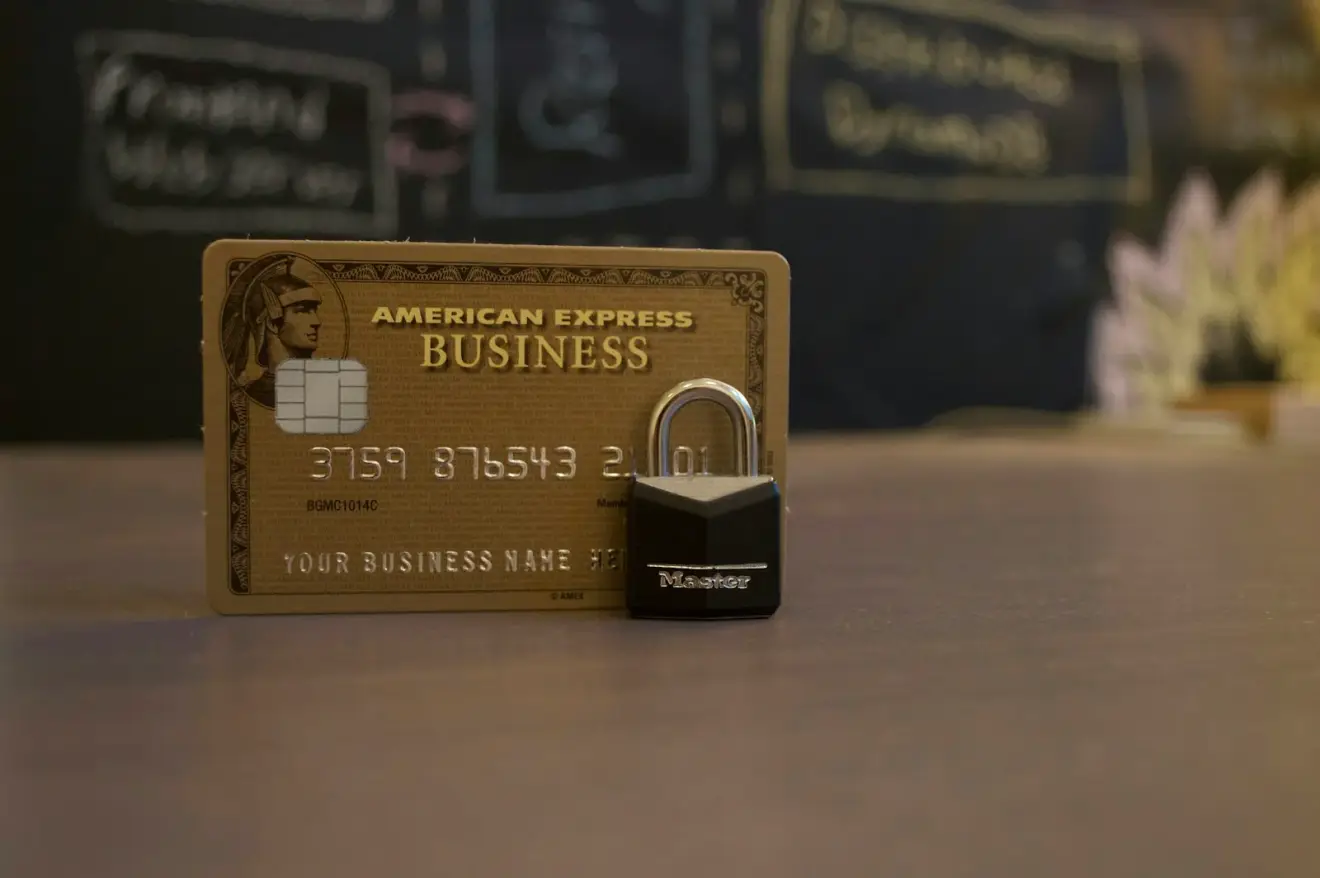 An American Express sample business card beside a small padlock on a counter