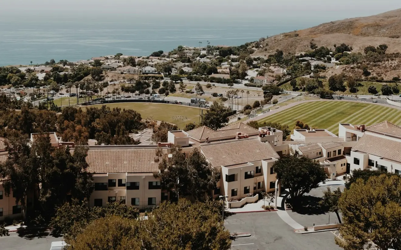 Pepperdine University campus buildings and playing fields overlooking the Pacific Ocean.