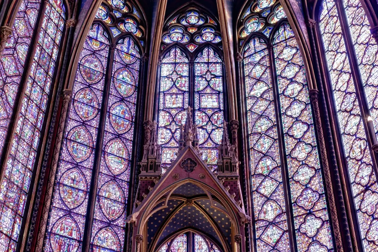 Tall stained-glass windows beneath the painted vaults of Sainte-Chapelle in Paris