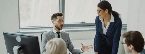 Four colleagues discussing work around an office table